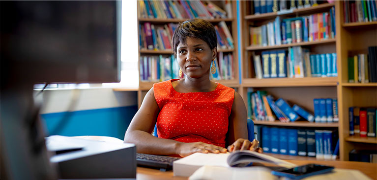 Female student at desk using computer 