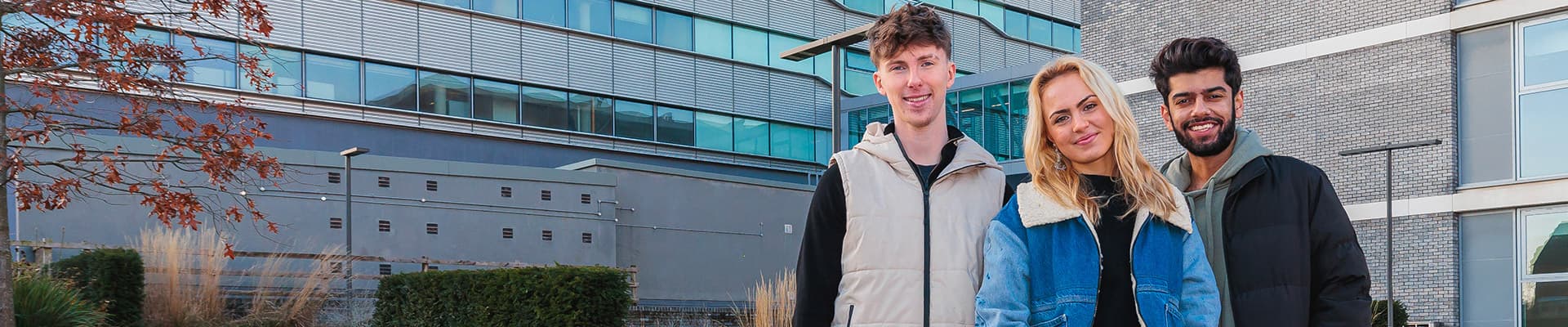 Three students stood outside on the campus