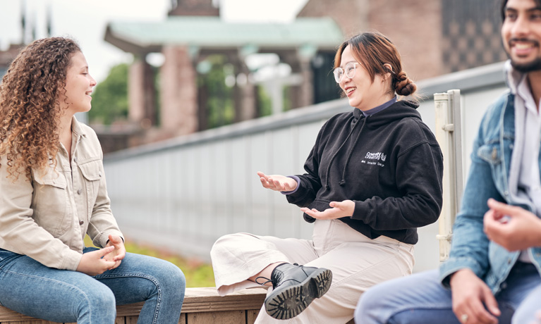 A group of students sat together on the rooftop garden in The Hub.