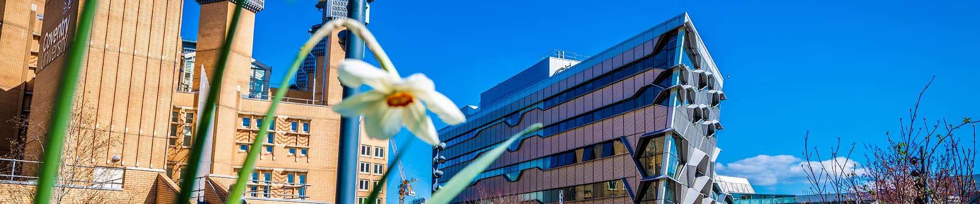 Outside of the Sir Frank Whittle building and the library with a blue sky