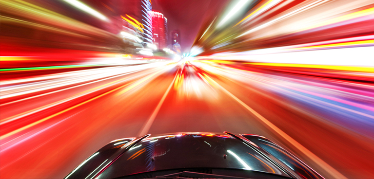 Car driving down blurred colourful road