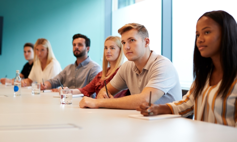 Six people looking across a long table