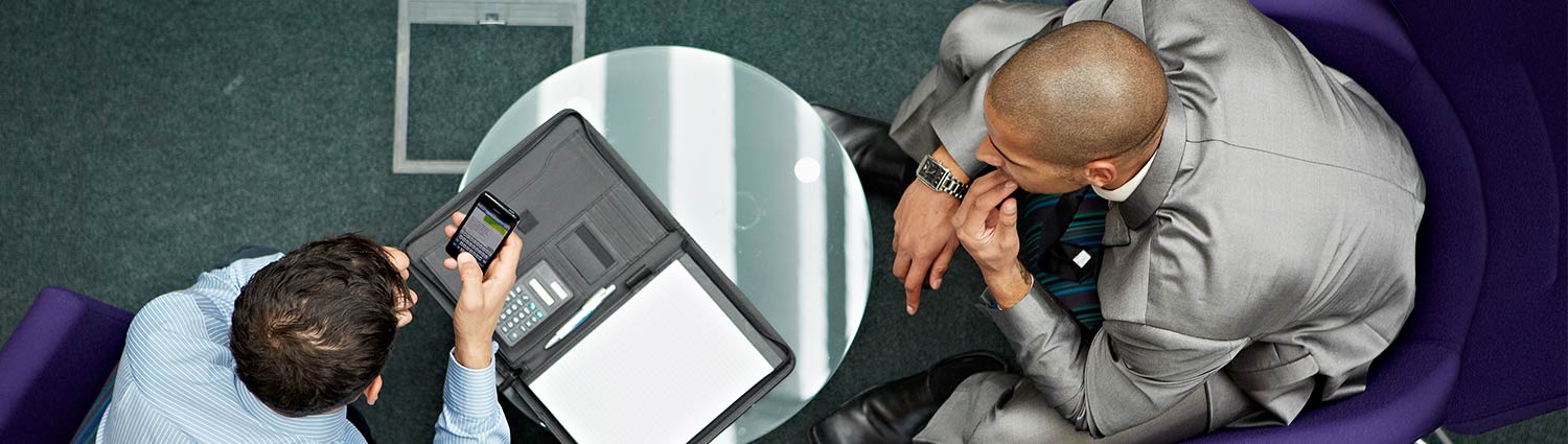 Two people looking at a laptop over a table