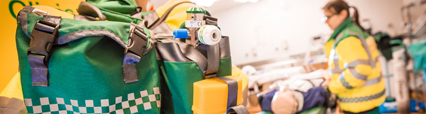 Close up view of a paramedic bag with a paramedic in the background