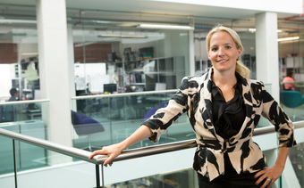 Portrait of Dr Ann-Marie Nienaber stood against a metal and glass banister