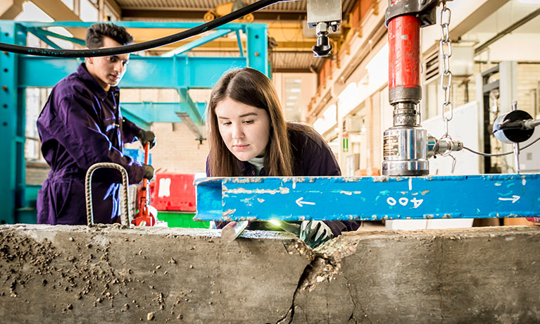 Female student using equipment in structures laboratory.