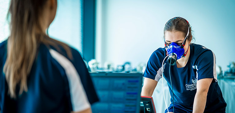 Student exercising with monitoring mask on