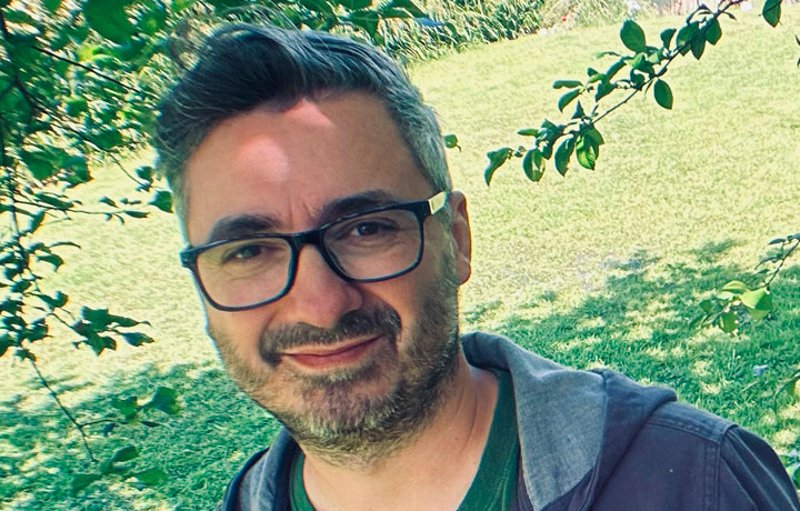 Dan Hopkins stood under a tree in a park on a sunny day