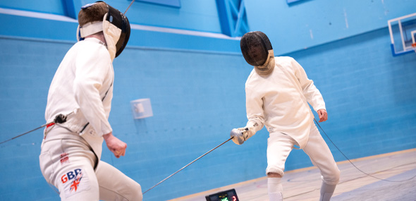 two students playng against each other in fencing