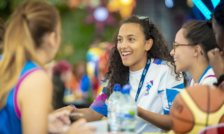 three smiling students chatting