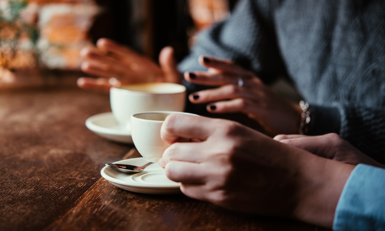 Two women having a discussion over a cup of coffee