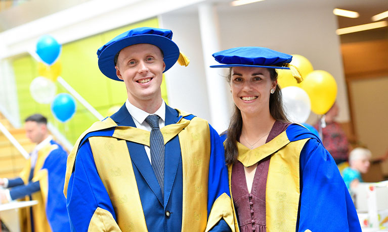 Two postgraduate researchers at the graduation ceremony
