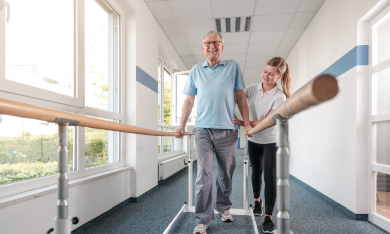 Senior Patient and physical therapist in rehabilitation walking exercises