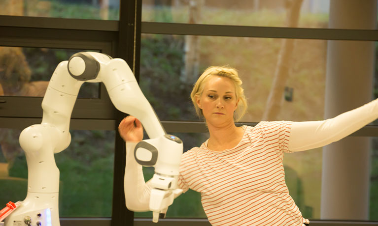 woman behind separate robot arm