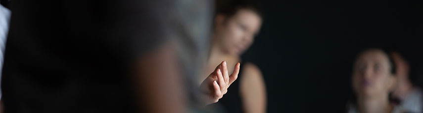 a hand of a dancer is in focus while background dancers are not in focus