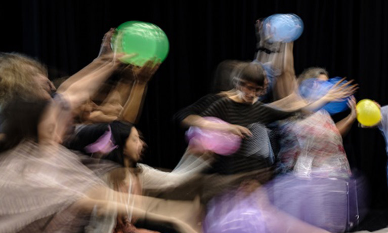 a blurry photo of people dancing with balloons