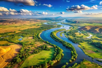 A horizon view of rivers flowing through fields and mountains with blue skies and fluffy clouds