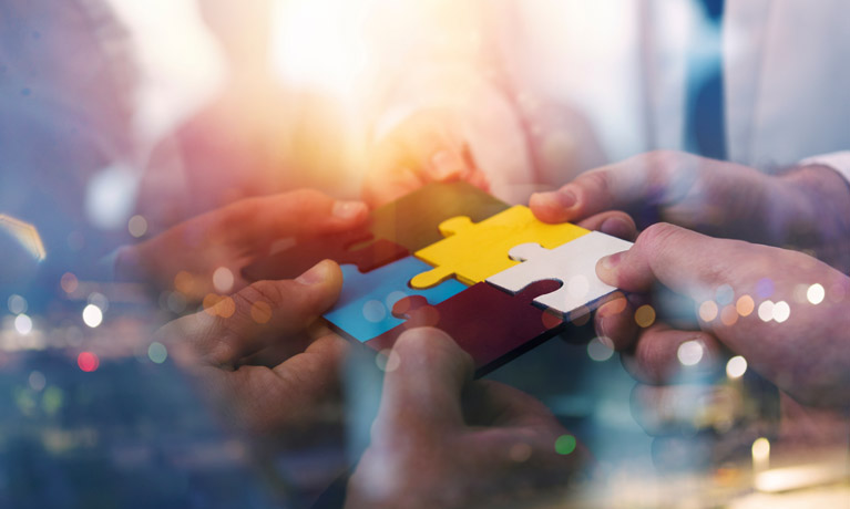 Hands holding jigsaw pieces and fitting them together