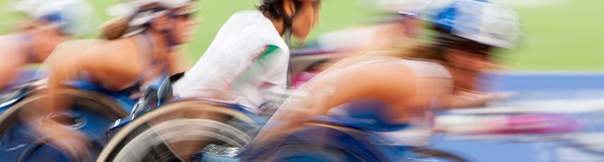 Competition wheelchair racing in motion at a stadium