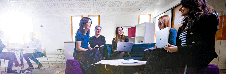 Group of female colleagues sat in meeting.