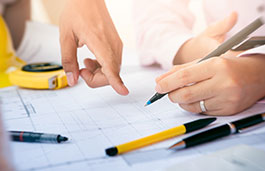 Close up of hands with one pointing and the other holding a pencil making notes