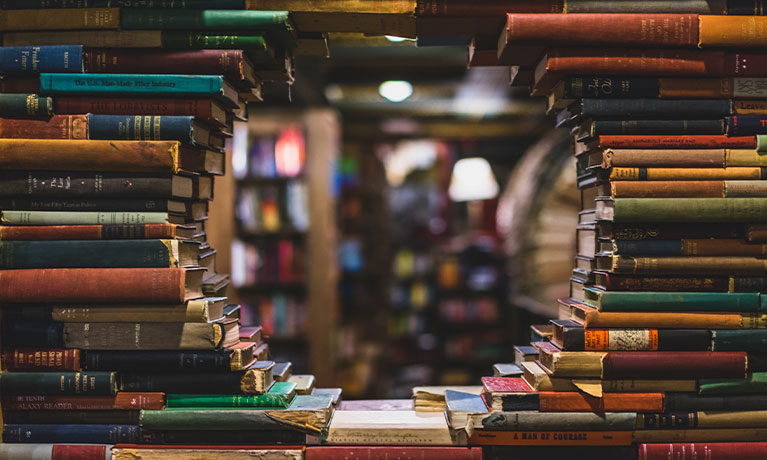 Books on a shelf with a hole