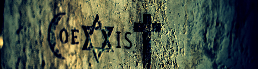 The word Coexist carved into a stone wall. Some of the letters are formed by the Islamic crescent, Star of David, and Christian Cross