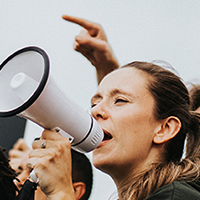 Woman yelling into a megaphone at a protest