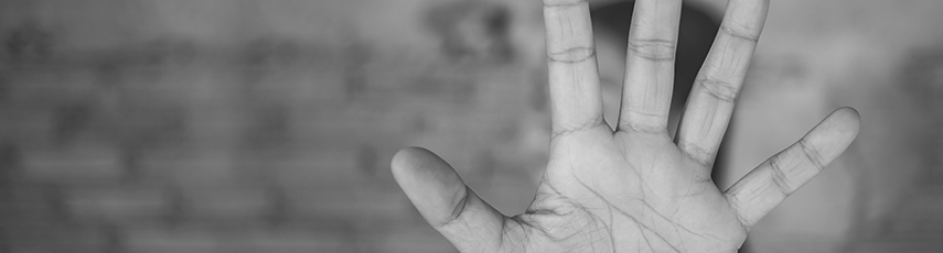 Woman with arm outstretched and hand up in a stop gesture