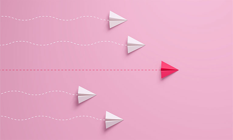 Women's leadership concepts with red paper airplane leading among white on pink background