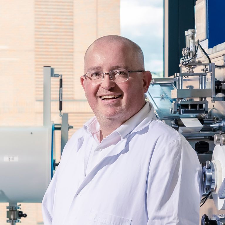 Alexander Roberts smiling in a lab within the C-ALPS building