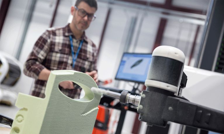 A man in a checked shirt using a CNC milling machine