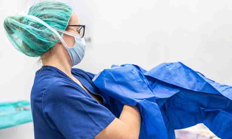 healthcare worker opening a ppe apron