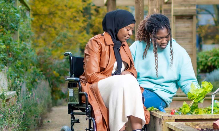 two students gardening one is in a wheelchair