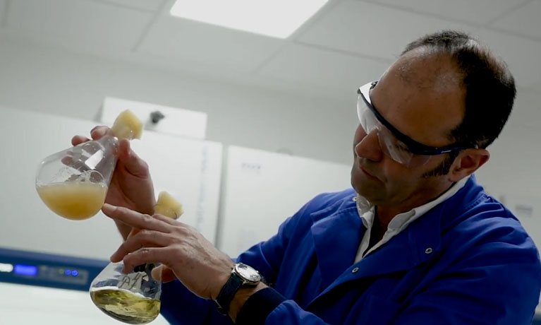 Man wearing glasses and protective clothing in a lab environment