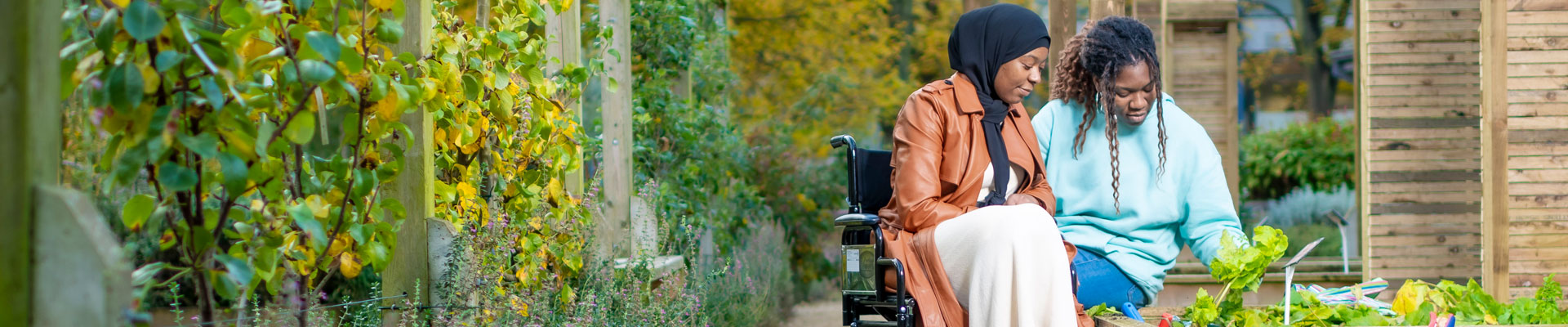 Two students, one in a wheelchair, in the edible herb garden on campus.