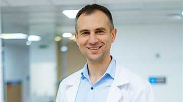 Man in labcoat looking at the camera