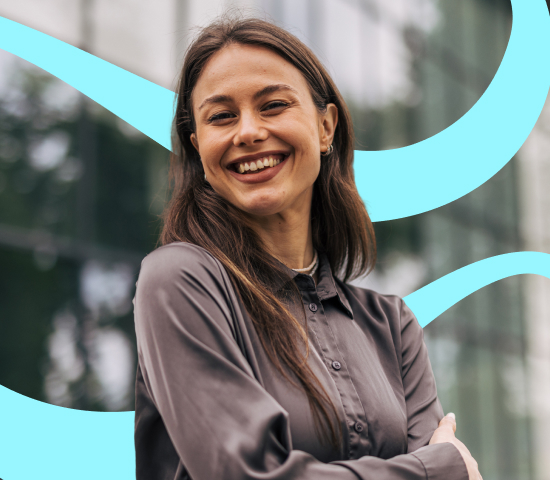 Smiling woman with long brown hair wearing a gray button-up shirt, standing outdoors in front of a glass building with abstract blue shapes in the background.