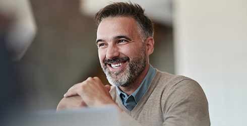 Smiling middle-aged name holding his hands