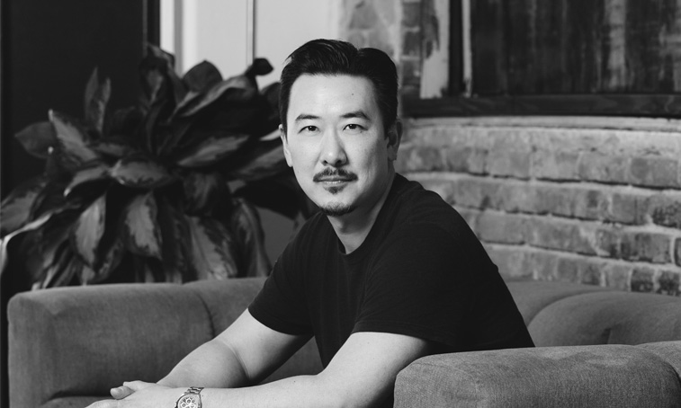 David Imai sat on a sofa in a modern office setting