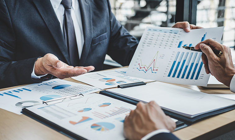 People looking through some finance data on sheets of paper
