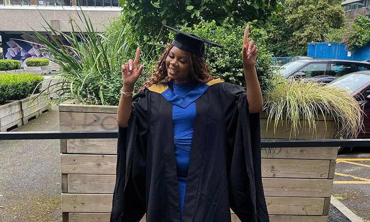 Phoebe Lewin stood in her graduation gown and hat smiling