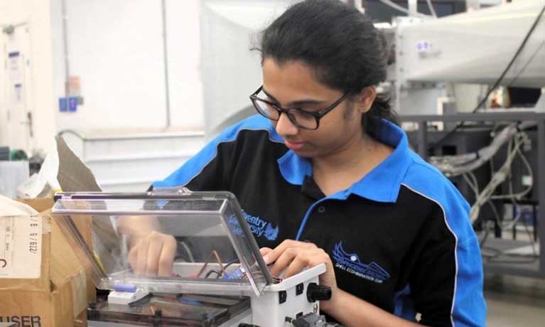 Sri working on a circuit box Sri working on a circuit box in a lab
