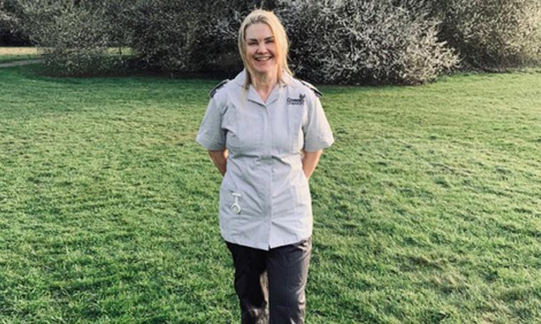 Tracey stood outside on grass smiling at the camera