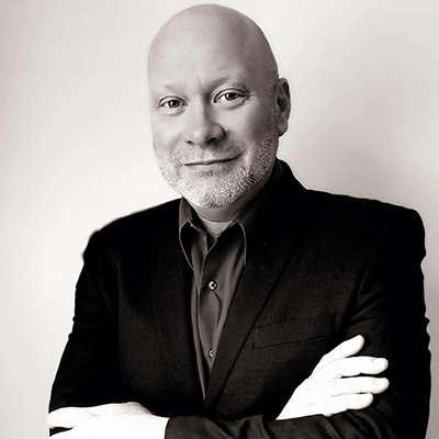 A black and white close up of Adam Fenton smiling