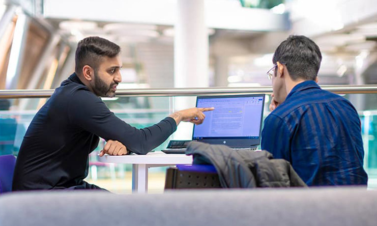 A couple of students working together on a laptop