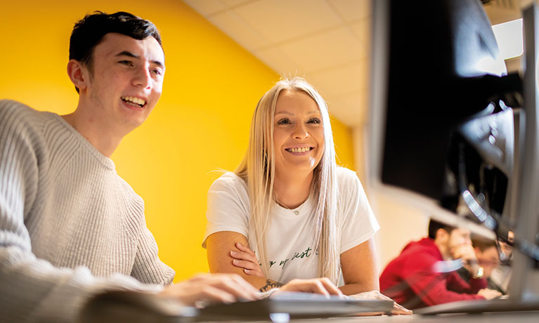 Two students sitting together in a classroom.