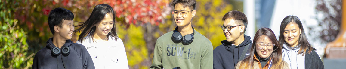 A group of international students walking outside on campus.