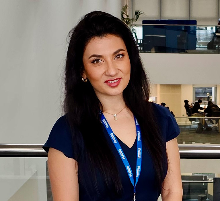 Portrait of Andreea Willmott against an open office background.