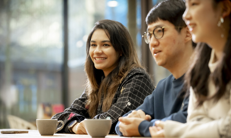 A group of international students at a cafe table.